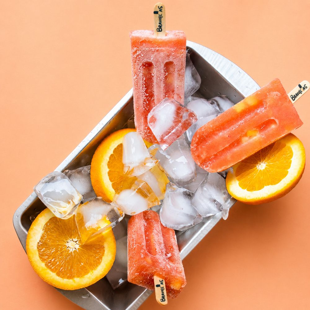 Paletas artesanales frutales Bravoletas con naranja y hielo, ideales para eventos en Costa Rica